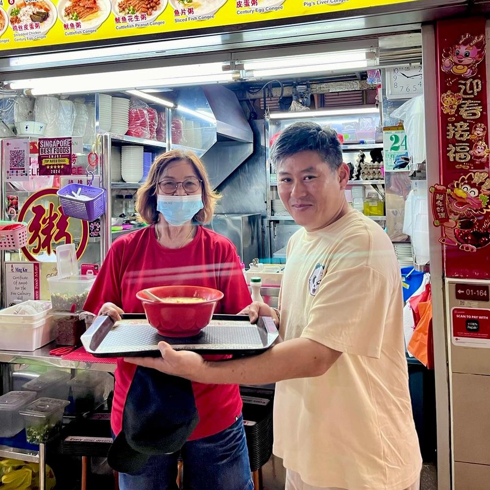 Ming Kee's owner handing over a bowl of porridge at the counter
